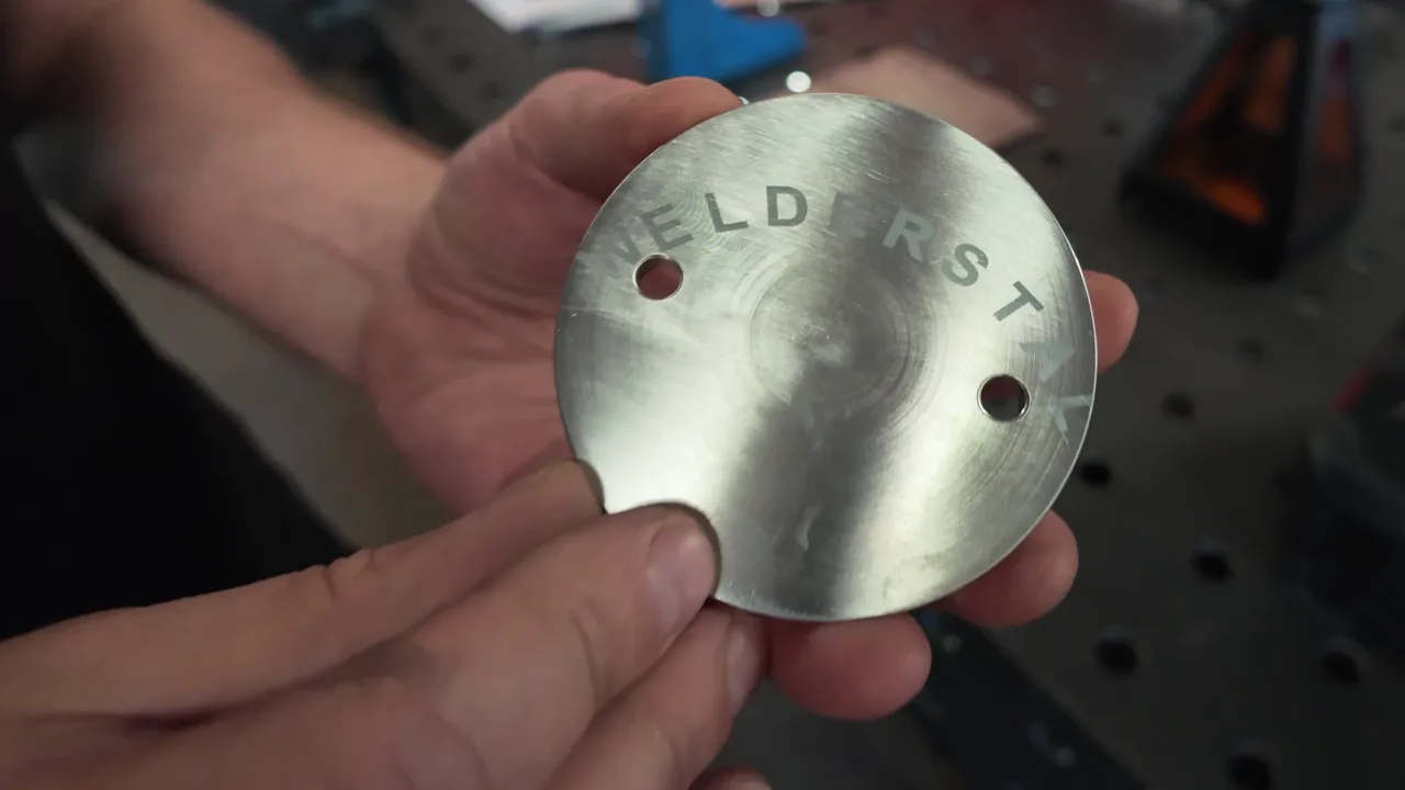 Napis wykonany ręczną znakowarką laserową na aluminiowym krążku